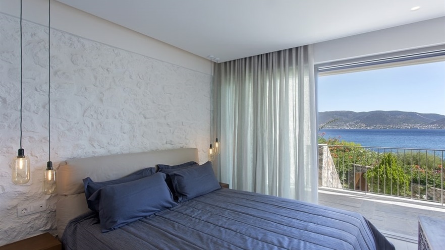 Master bedroom with open curtains and sea view