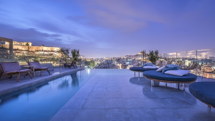 Pool with round sunbeds with view to the city and the Acropolis at night