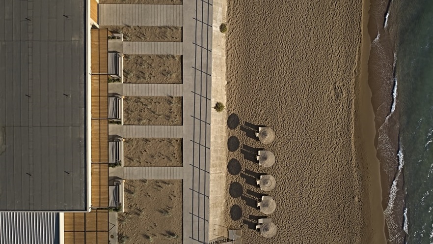 Beach with sunbeds and hotel courtyard from above