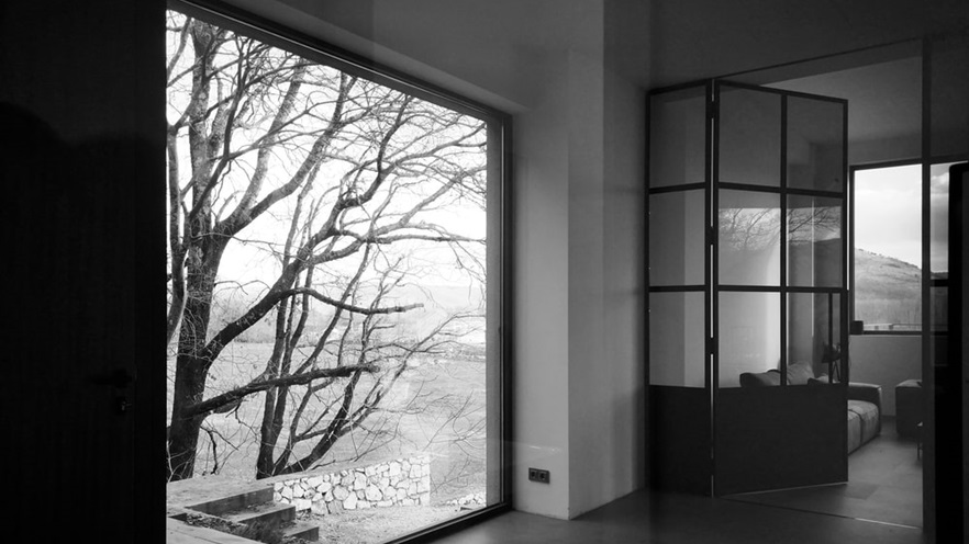 A large window looks at some trees outside